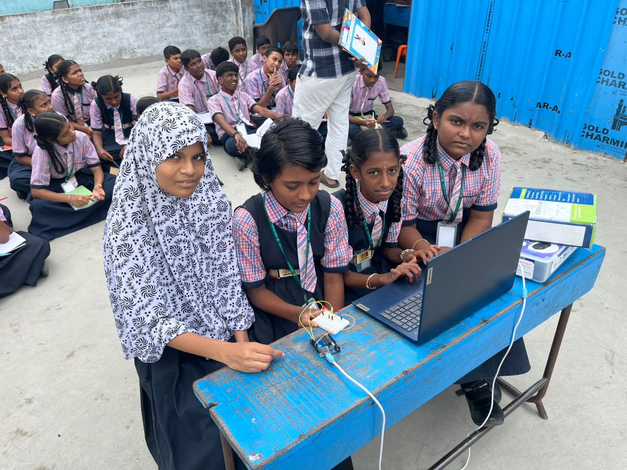 Students operating a laptop and microcontroller project at a 21C Lab workbench