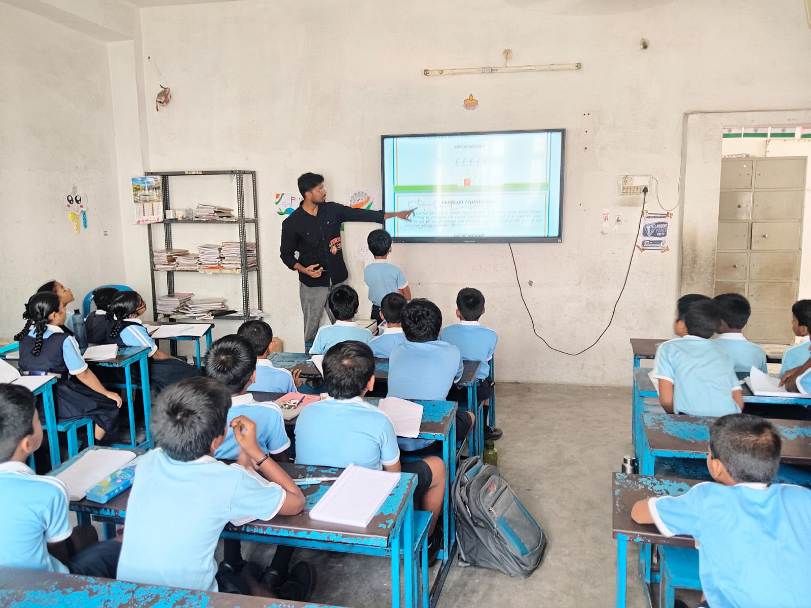 A trainer teaching students with a wall-mounted display in the Nxtera 21C Lab